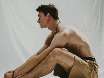 Male athlete doing stretching in a bright studio